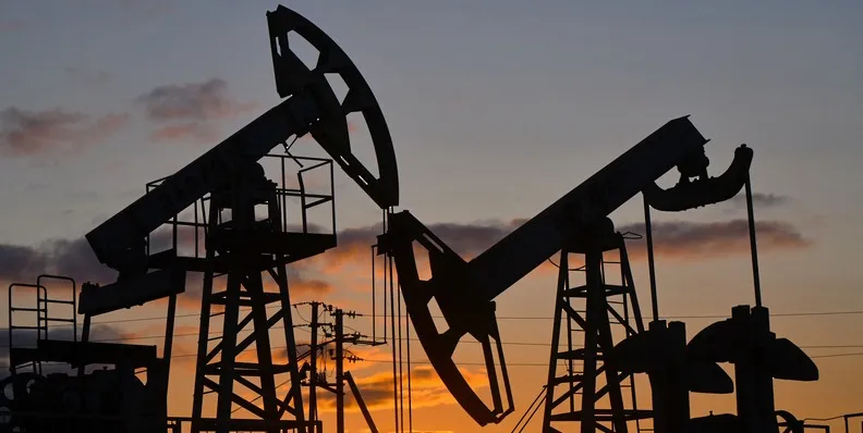 Нефтяные вышки на закате в Омане, символ экономического роста.